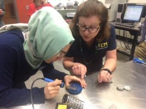 USNA STEM Center representative leads educator through soldering of SeaPerch robot